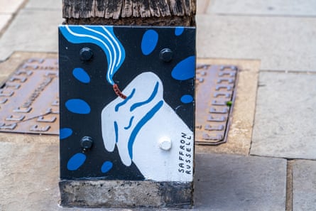 a small mural depicting a blown-out candle on a bollard