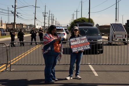 two people stand in front of a metal barricade