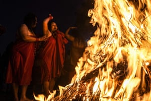 Kathmandu, Nepal. Hindu devotees warm themselves around bonfires after bathing in the Shali River during the Swasthani Brata Katha festival