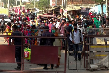 Nepalese migrant workers wait to cross the border