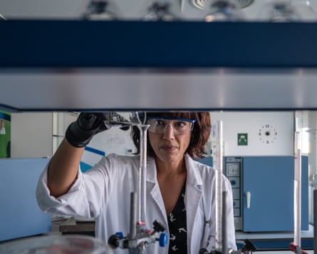 Almudena Martínez Carrillo pouring water from a glass beaker into a phial