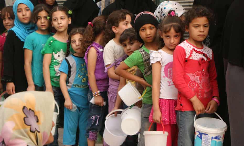 Syrian children wait to receive food in the rebel-held side of Aleppo