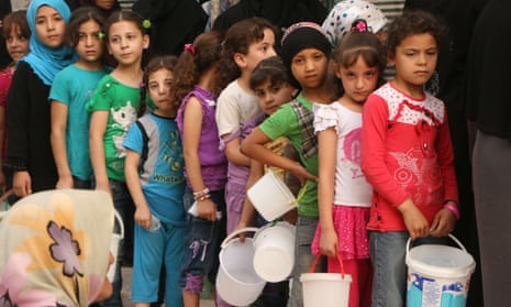 Syrian children queue up to receive food aid food in Aleppo, September 2015