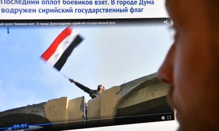 A screengrab from a video aired on Russian media shows a man reportedly waving a Syrian flag from a building in Douma.