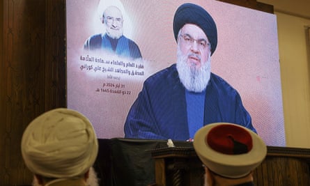 Hezbollah’s leader, Sayyed Hassan Nasrallah, gives a televised address on a large screen