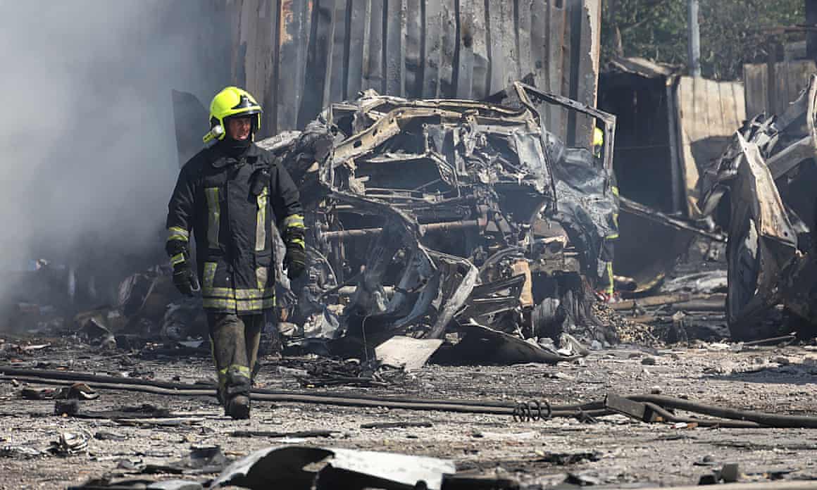 A firefighter at the site of smoldering wreckage caused by a rocket strike