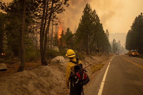 A firefighter watches as the Caldor fire approaches in Meyers, south of South Lake Tahoe.The Caldor fire has scorched nearly 312 sq miles since breaking out on 14 August.
