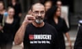 Andrew Malkinson, wearing a t-shirt that reads 'Innocent, and not the only one', holds up his fist