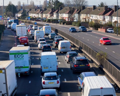 A busy six-lane road with homes next to it