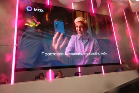 Receptionists sit in front of an electronic panel advertising Max