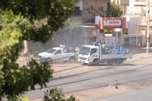 Two vehicles with police and security officers drive to protests in Omdurman in Sudan.