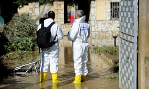 Forensic personnel check the house where nine people died.