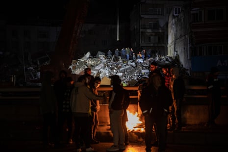 Earthquake survivors spend the night as around a fire in Iskenderun Turkey.