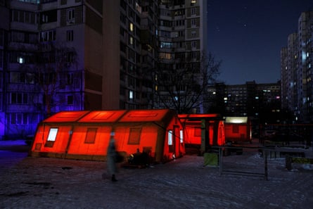 A woman walks past a red tent
