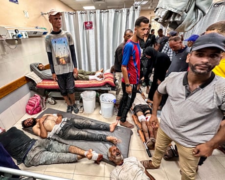 Wounded Palestinians lie on the floor in the emergency ward of the Nasser hospital in Khan Younis after sustaining injuries while seeking humanitarian aid on 24 July.