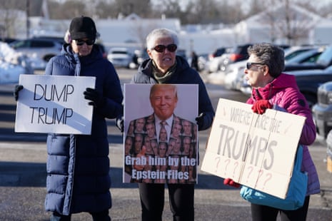 people hold signs that read ‘dump Trump’ ‘grab him by the Epstein files’ and ‘where are the Trumps’