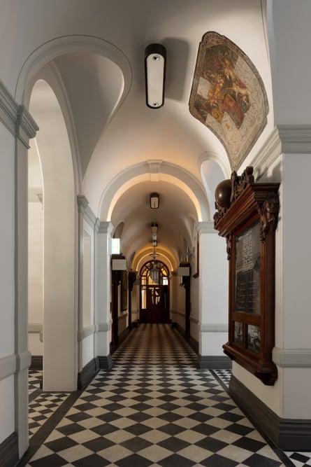 A long hallway with a checkerboard tile floor and tall ceiling