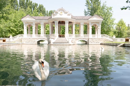 A swan lake with ostentatious gazebo in the background