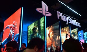 Visitors wander in front of the Playstation posters at the 2018 E3 expo