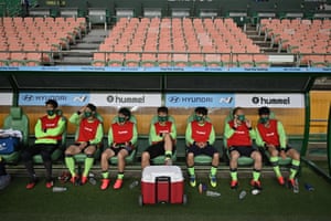 Jeonbuk Motors’ players sit in the dugout prior to the opening game of South Korea’s K-League.