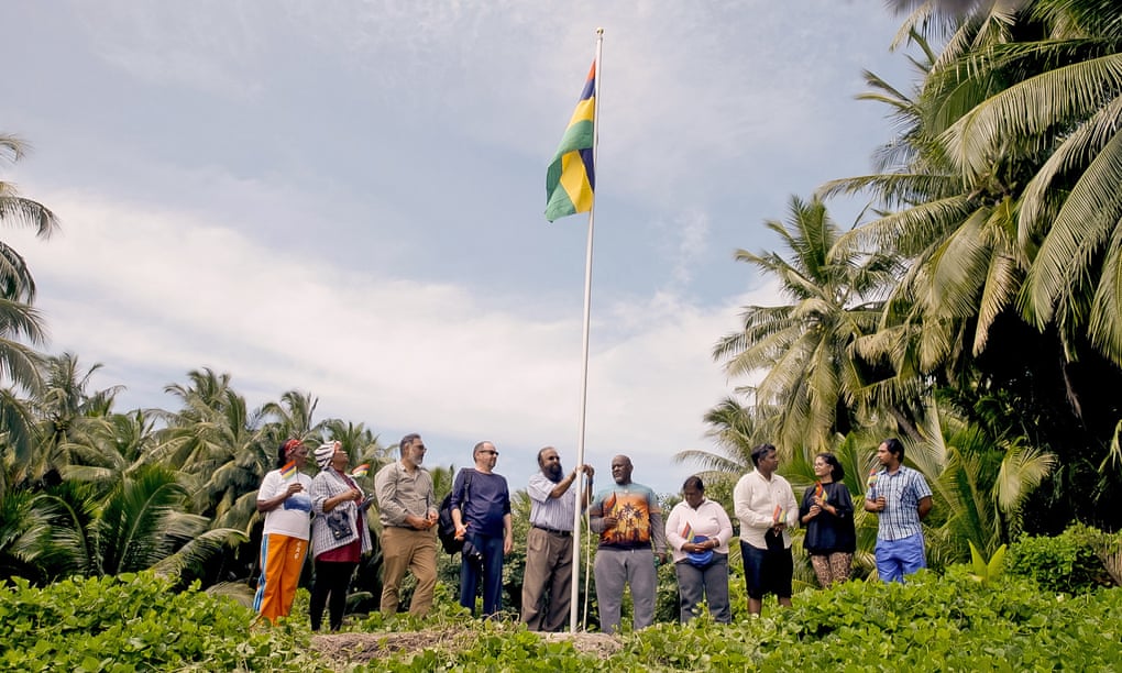 Officials raise the Mauritian flag above an atoll on the Chagos Islands, February 2022.