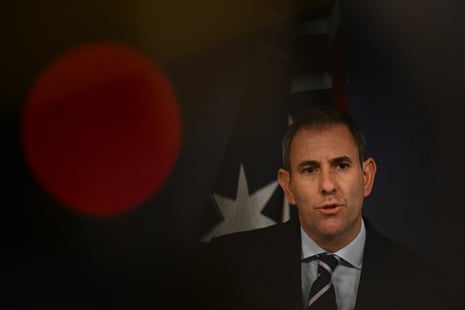 A man in a suit surrounded by a dark background.
