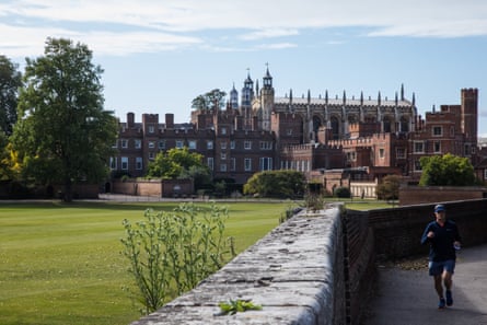 A man runs past Eton college and Eton college chapel.