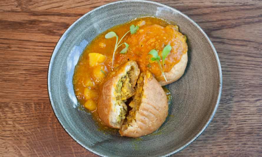 A round blue plate of aloo kachori, crisp bread pockets filled with potato curry.