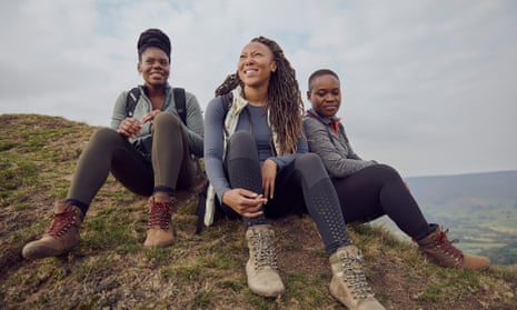 Rhiane Fatinikun (centre of three women hikers), founder of Black Girls Hike on a hill in the UK while on a hike.