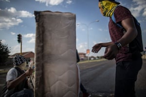 Masked students set up a mattress as a barricade during a protest at the North West University Vaal campus
