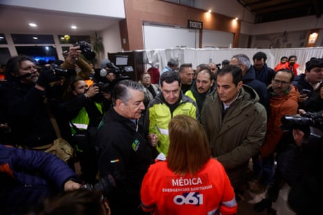 Juanma Moreno speaks with an emergency responder at the Adamuz sports centre in Córdoba.