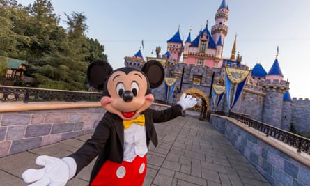 Mickey Mouse poses in front of Sleeping Beauty Castle at Disneyland Park 