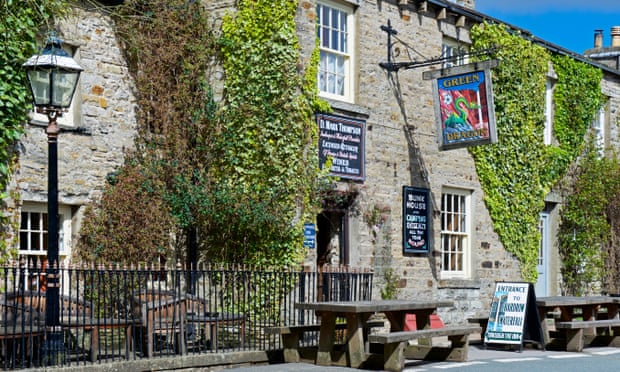 The stone exterior of the Green Dragon pub, with brightly painted pub sign featuring a dragon