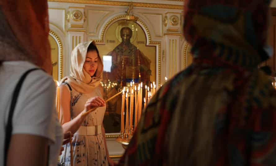 A Russian-speaking expatriate celebrating Easter lights a candle at the Orthodox Christian Church in Sharjah, United Arab Emirates, Sunday, April 24, 2022. (AP Photo/Isabel Debre)