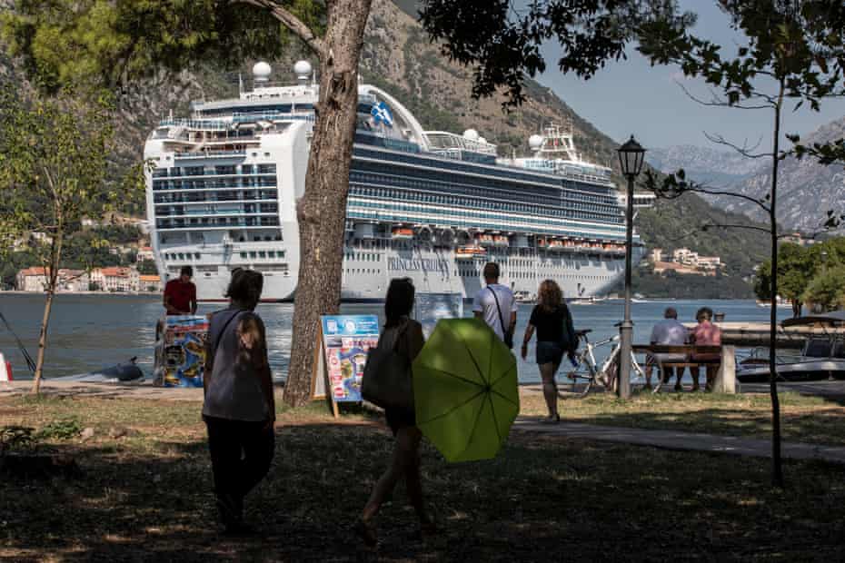 Tourists and locals in city park look at the ship Emerald Princess