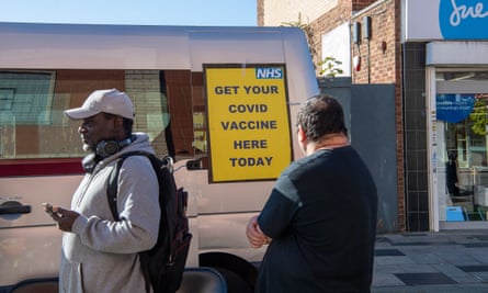 People queuing for Covid-19 booster jabs at a mobile NHS vaccination service in Slough High Street.
