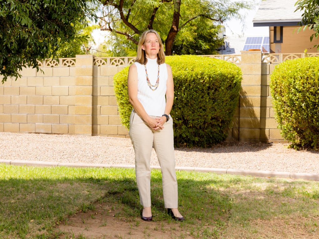 Woman standing outside by a tree and shrubbery