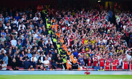 How the other half live: Spurs fans look on in silence as Arsenal fans sing in full voice.