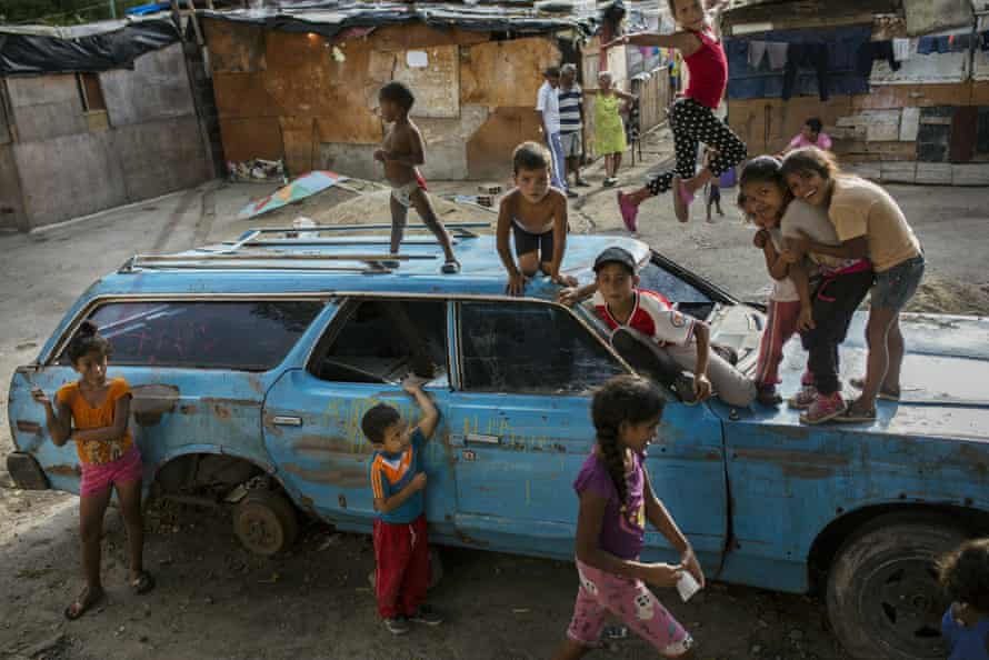 Children play on top of an abandoned car at the Aguerridos Liberator shanty town in Caracas, Venezuela, 9 May