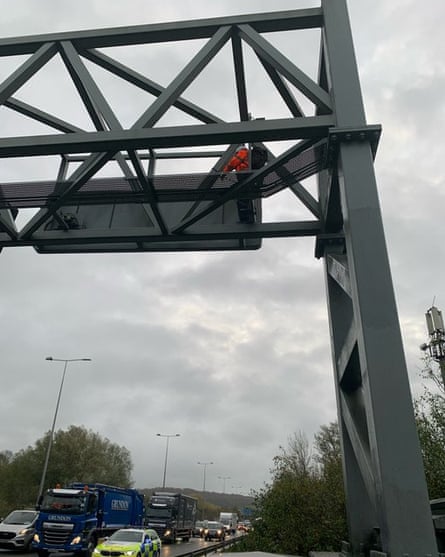 Photo posted on Twitter of a Just Stop Oil protester on a gantry on the M25.