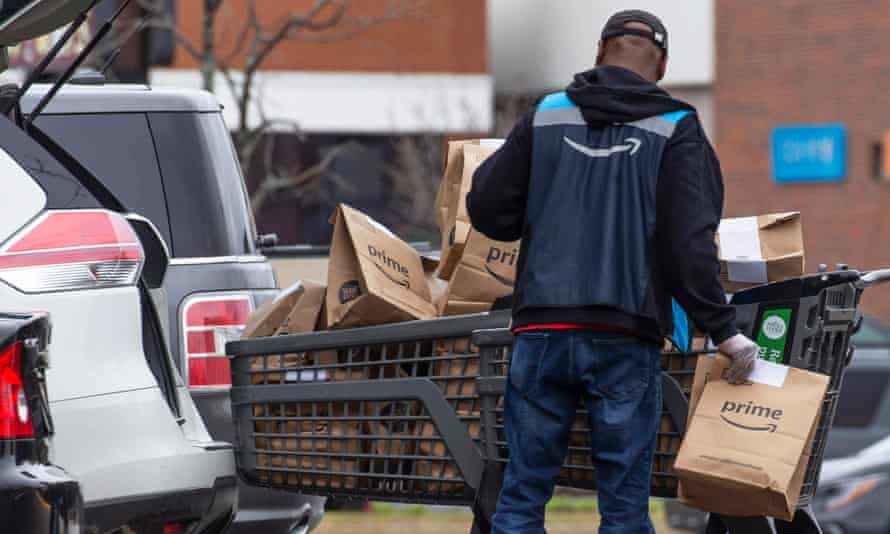 An Amazon Prime worker loads bags of online shopping into a vehicle outside a Whole Foods in Cambridge, Massachusetts.
