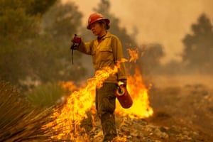 Mormon Lake Hotshots Supt Sara Sweeney uses a drip torch to set a backfire to protect mountain communities from the Bobcat fire in the Angeles national forest on Thursday north of Monrovia, California
