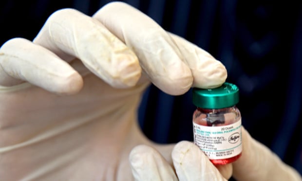 An Indian health volunteer holds a vial containing the pulse polio oral vaccine in Bangalore, India, February 28, 2022.