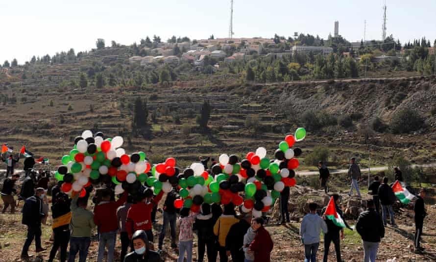 Palestinians hold balloons during a protest against Pompeo’s visit, near the Israeli settlement of Psagot.