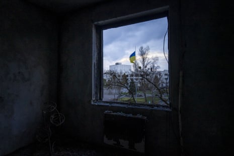 A Ukrainian flag is seen outside the window of a demolished room in an apartment building in Borodyanka.