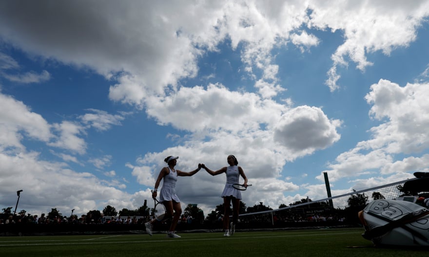 Alicia Barnett and Olivia Nicholls of Great Britain high five after winning a game during their defeat in the ladies’ doubles to Nadia Kichenok of Ukraine and Raluca Olaru of Romania on Court 8 .