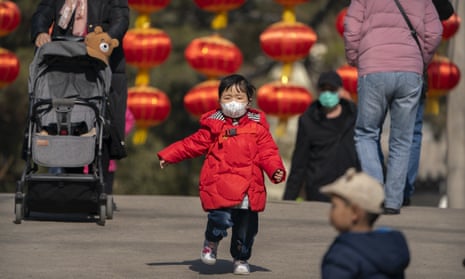 A child wearing a face mask runs along a path in China
