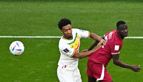 Almoez Ali en Abdou Diallo uit Senegal vechten om de bal.