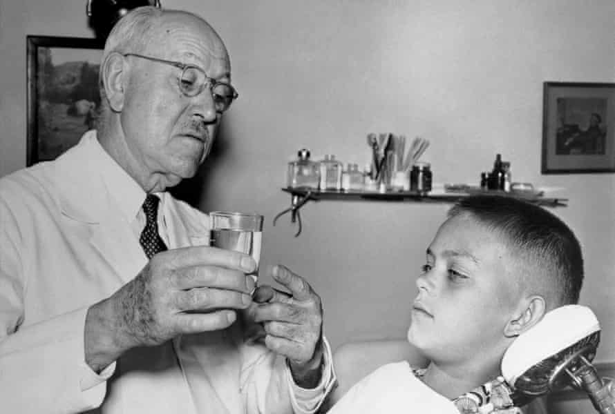 Dr Frederick McKay explains fluoride to a young patient.