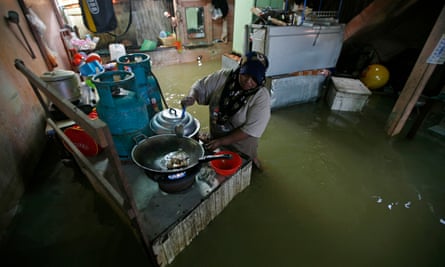 A woman prepares food in her flooded house in Rantau Panjang, north Malaysia.